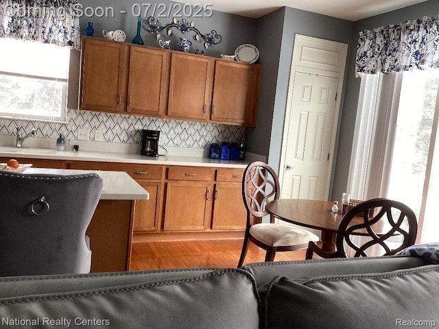 636 Zion Ct S, Howell, MI 48843 - kitchen with backsplash, light wood-style flooring, brown cabinets, and light countertops