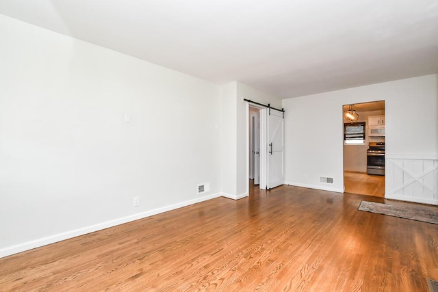 1624 Fulton St, Kalamazoo, MI 49001 - unfurnished room with a barn door and wood finished floors