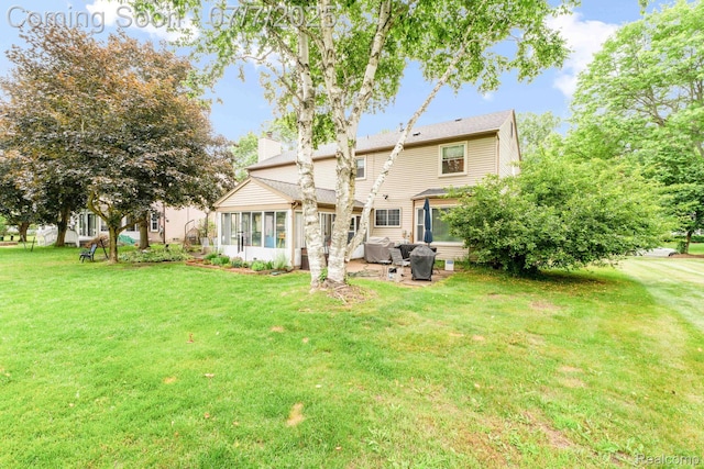 6611 Windmill Ln, West Bloomfield, MI 48324 - rear view of house featuring a sunroom, a chimney, and a yard