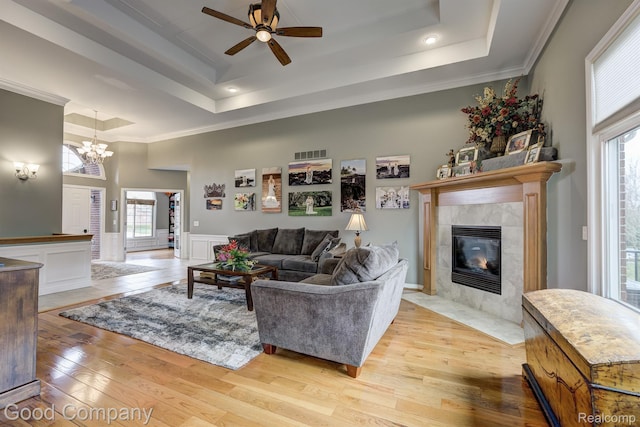 63705 Monticello E, Washington, MI 48095 - living area with a raised ceiling, ornamental molding, light wood-style flooring, a tile fireplace, and ceiling fan