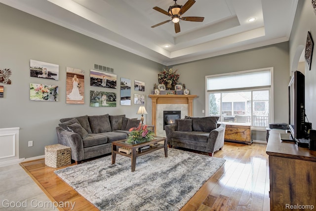 63705 Monticello E, Washington, MI 48095 - living area featuring a ceiling fan, a raised ceiling, a tiled fireplace, light wood-style flooring, and recessed lighting