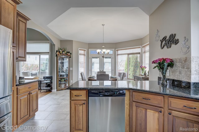 63705 Monticello E, Washington, MI 48095 - kitchen featuring stainless steel appliances, arched walkways, a chandelier, dark stone counters, and a peninsula