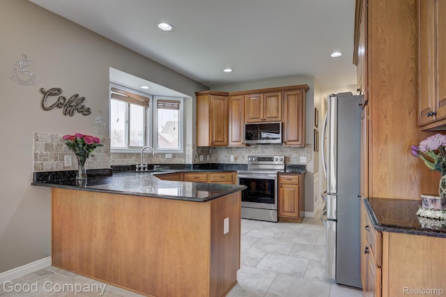63705 Monticello E, Washington, MI 48095 - kitchen with appliances with stainless steel finishes, a peninsula, backsplash, brown cabinets, and recessed lighting
