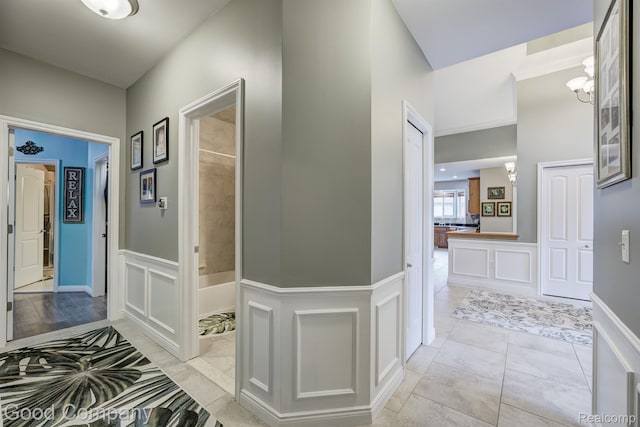 63705 Monticello E, Washington, MI 48095 - hallway featuring wainscoting, a decorative wall, and a chandelier