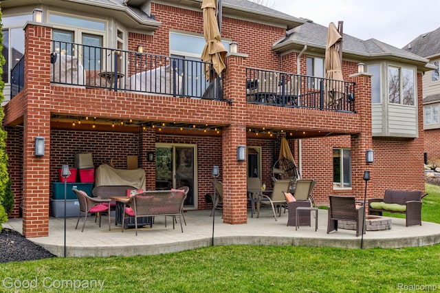 63705 Monticello E, Washington, MI 48095 - rear view of property featuring brick siding, a balcony, and a patio area