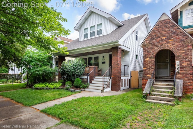 1424 Lakepointe St, Detroit, MI 48230 - view of front of home with a porch, brick siding, a front yard, and a shingled roof