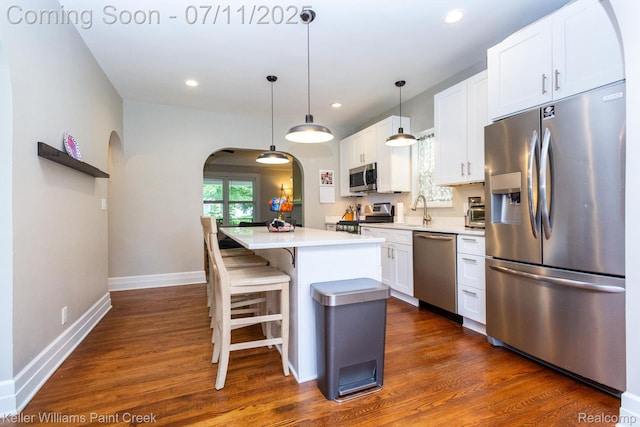 1424 Lakepointe St, Detroit, MI 48230 - kitchen featuring appliances with stainless steel finishes, arched walkways, a center island, dark wood-style flooring, and recessed lighting