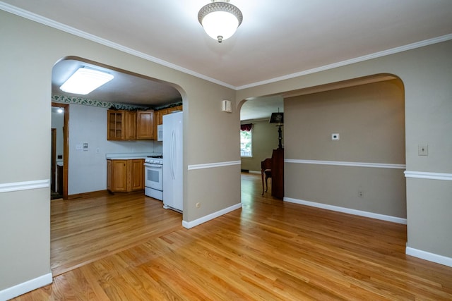 3813 Green Acre Dr, Saint Joseph, MI 49085 - kitchen featuring arched walkways, white appliances, brown cabinetry, light wood finished floors, and ornamental molding