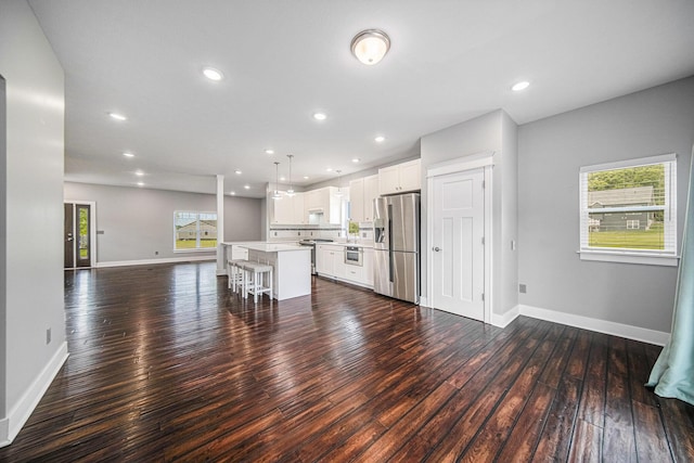2807 Bartlett Rd, Pleasant Lake, MI 49272 - kitchen featuring appliances with stainless steel finishes, open floor plan, dark wood finished floors, light countertops, and a center island