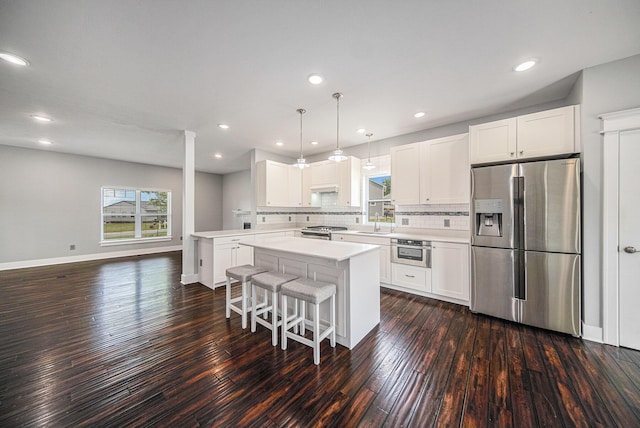 2807 Bartlett Rd, Pleasant Lake, MI 49272 - kitchen with stainless steel appliances, a kitchen island, backsplash, light countertops, and dark wood finished floors