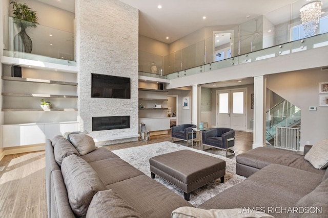 12974 Boulderway Trl, Grand Haven, MI 49417 - living area featuring a towering ceiling, wood finished floors, recessed lighting, and a fireplace