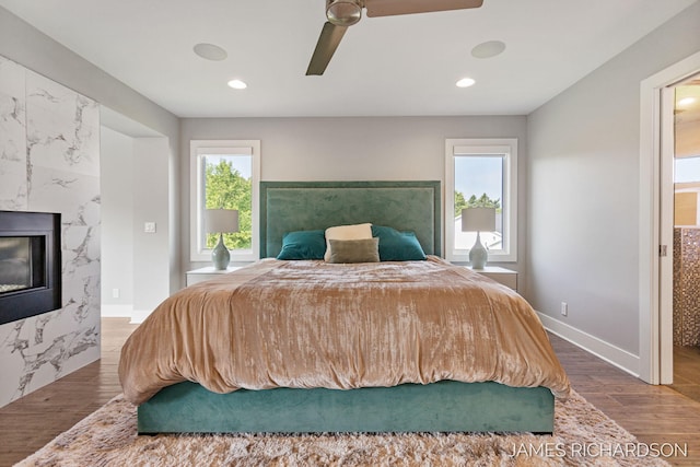12974 Boulderway Trl, Grand Haven, MI 49417 - bedroom featuring wood finished floors, recessed lighting, a high end fireplace, and a ceiling fan