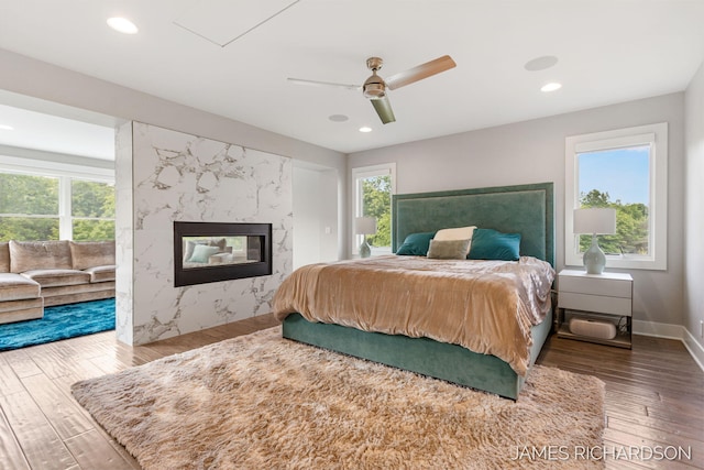12974 Boulderway Trl, Grand Haven, MI 49417 - bedroom with wood finished floors, multiple windows, a premium fireplace, recessed lighting, and ceiling fan