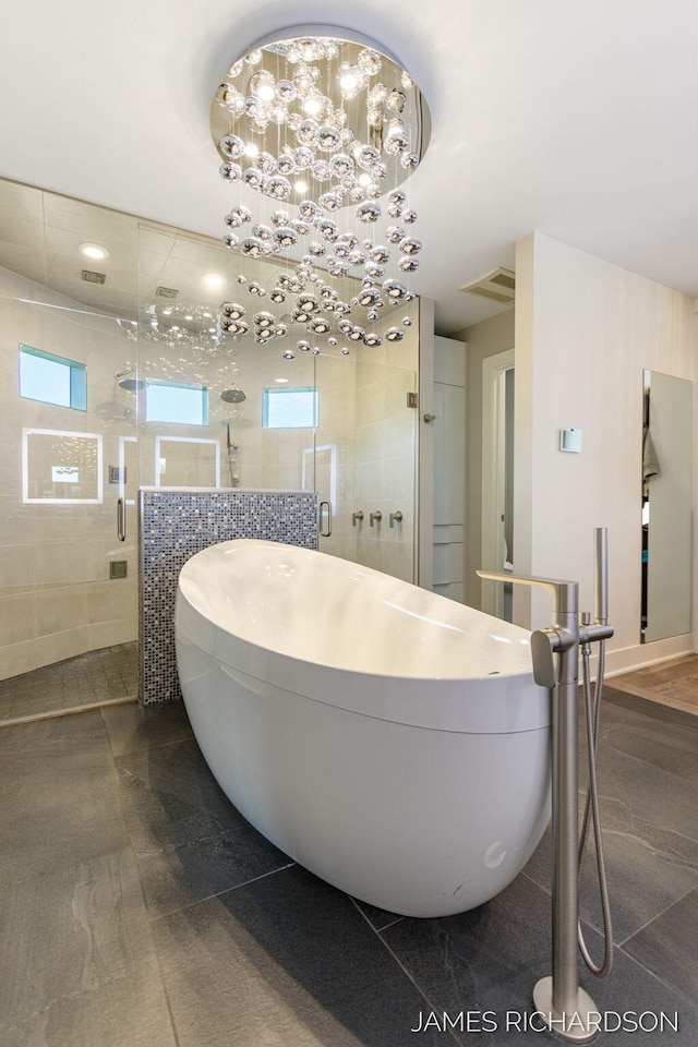 12974 Boulderway Trl, Grand Haven, MI 49417 - full bath with a freestanding tub, a stall shower, tile walls, and a chandelier
