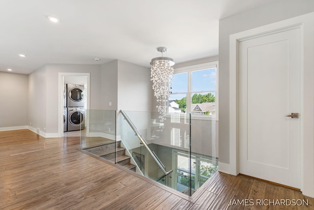 12974 Boulderway Trl, Grand Haven, MI 49417 - stairway featuring stacked washer / dryer, wood finished floors, a chandelier, and recessed lighting