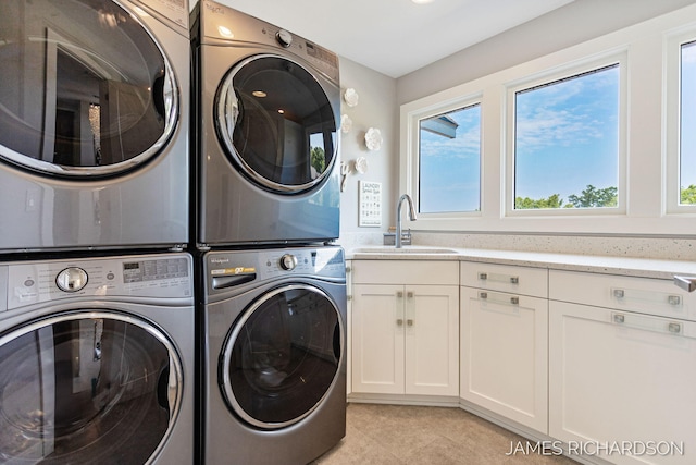 12974 Boulderway Trl, Grand Haven, MI 49417 - laundry room with stacked washer and clothes dryer, cabinet space, and light tile patterned flooring