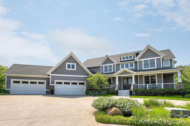 12974 Boulderway Trl, Grand Haven, MI 49417 - craftsman-style house with driveway, covered porch, an attached garage, and stone siding