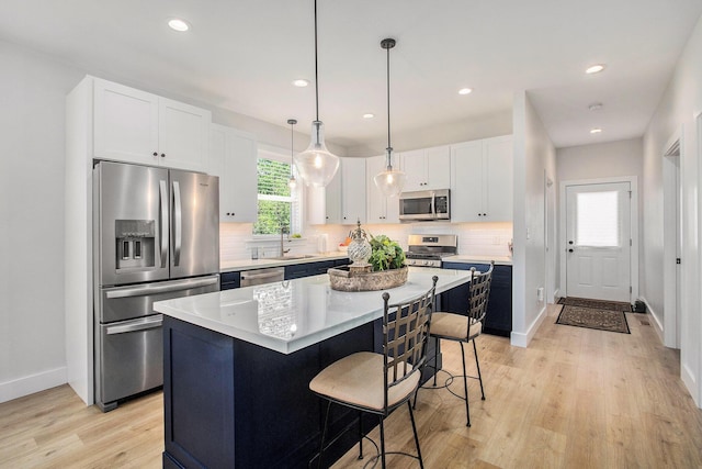765 S Haven Pl, South Haven, MI 49090 - kitchen with stainless steel appliances, light wood-style flooring, a center island, decorative backsplash, and light countertops