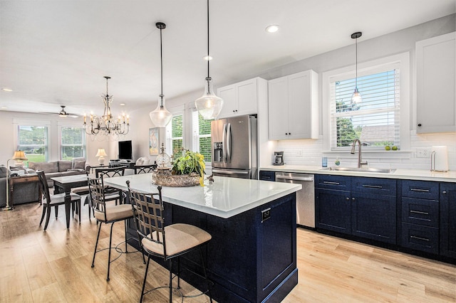 765 S Haven Pl, South Haven, MI 49090 - kitchen featuring appliances with stainless steel finishes, light wood-style flooring, a kitchen breakfast bar, light countertops, and backsplash