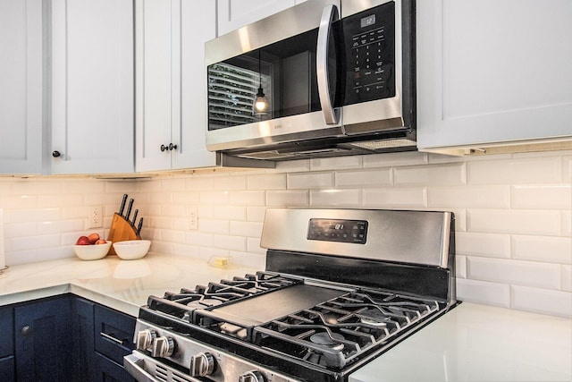 765 S Haven Pl, South Haven, MI 49090 - kitchen with stainless steel appliances, light countertops, tasteful backsplash, and white cabinetry