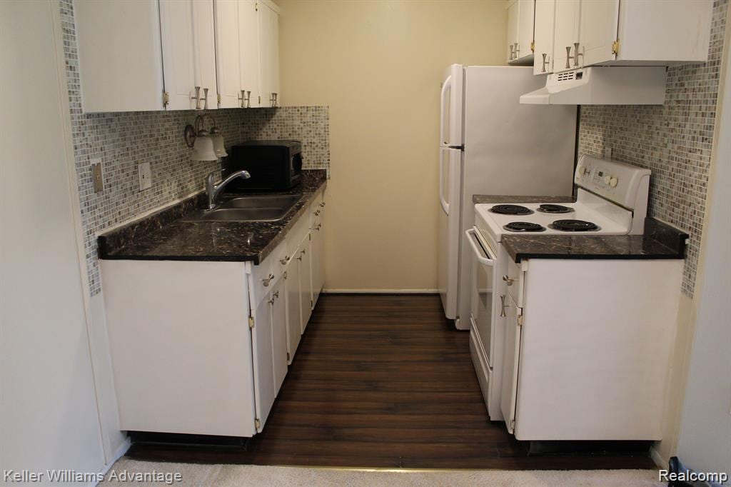 26790 Joy Rd Unit 11, Redford, MI 48239 - kitchen featuring under cabinet range hood, white range with electric stovetop, black microwave, and white cabinets