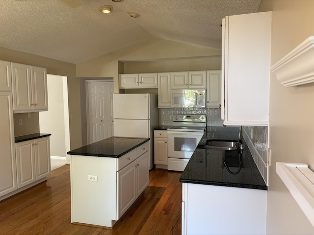 35595 Lone Pine Ln, Farmington Hills, MI 48335 - kitchen with white appliances, lofted ceiling, white cabinets, a center island, and decorative backsplash