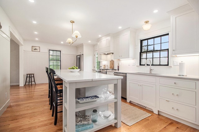 5145 Hensley Dr, Ann Arbor, MI 48103 - kitchen with stainless steel dishwasher, open shelves, a kitchen bar, a center island, and plenty of natural light