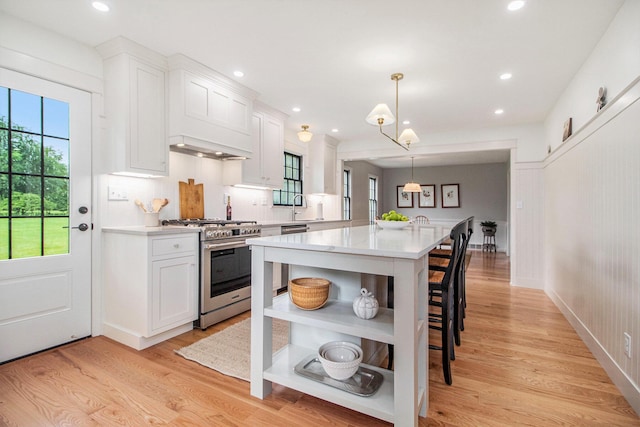 5145 Hensley Dr, Ann Arbor, MI 48103 - kitchen with stainless steel range with gas cooktop, open shelves, light countertops, white cabinetry, and healthy amount of natural light