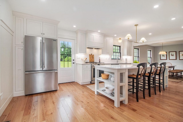 5145 Hensley Dr, Ann Arbor, MI 48103 - kitchen featuring high quality appliances, white cabinets, light countertops, light wood finished floors, and recessed lighting