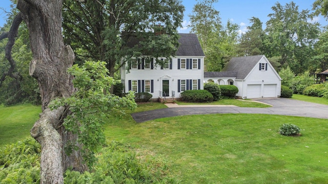 5145 Hensley Dr, Ann Arbor, MI 48103 - colonial-style house featuring asphalt driveway, a front yard, and a chimney