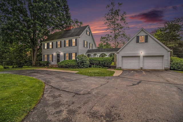 5145 Hensley Dr, Ann Arbor, MI 48103 - colonial inspired home with asphalt driveway, a chimney, a lawn, a garage, and roof with shingles
