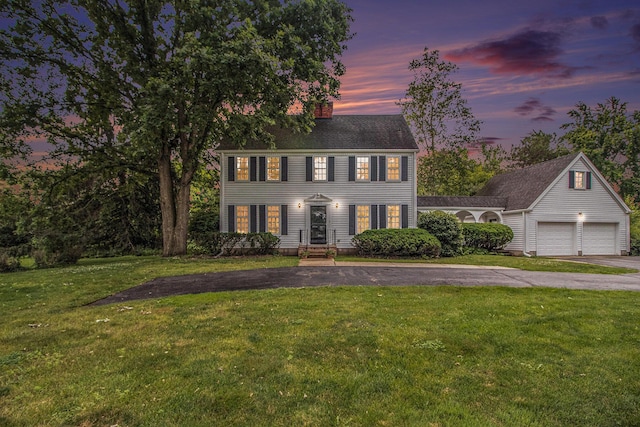 5145 Hensley Dr, Ann Arbor, MI 48103 - colonial-style house featuring asphalt driveway, a chimney, a front yard, and a garage
