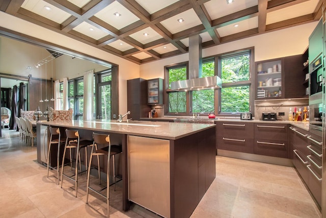 7085 Youngren Rd, Three Oaks, MI 49128 - kitchen featuring beam ceiling, coffered ceiling, healthy amount of natural light, backsplash, and light stone countertops