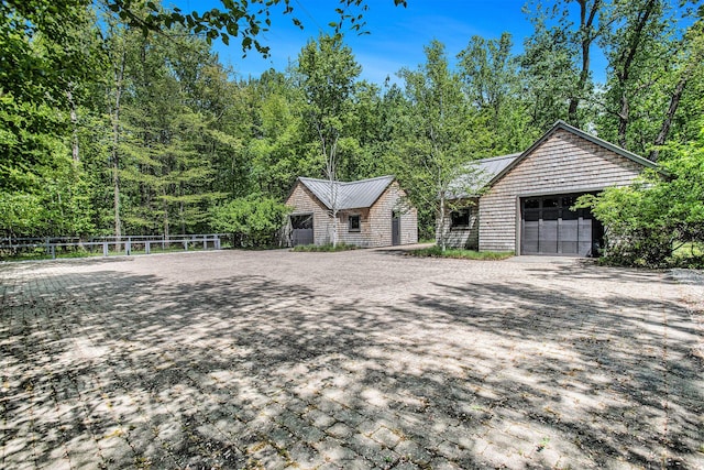 7085 Youngren Rd, Three Oaks, MI 49128 - view of front of property featuring a metal roof, a garage, a standing seam roof, and a wooded view
