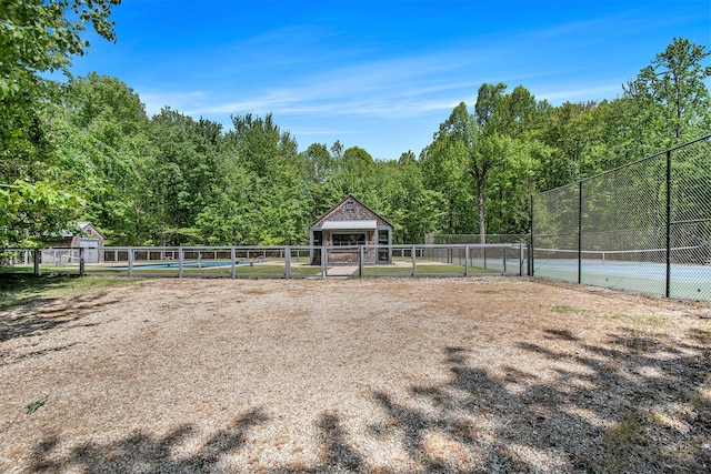 7085 Youngren Rd, Three Oaks, MI 49128 - view of yard featuring an outdoor structure, a tennis court, and a wooded view