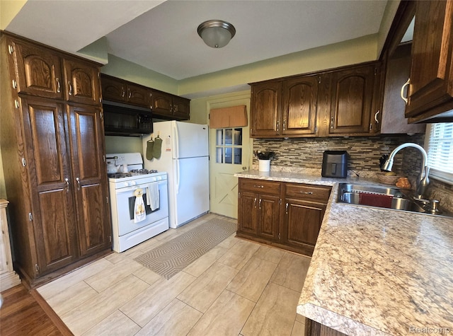 11019 Washington Ave, Mount Morris, MI 48458 - kitchen featuring white appliances, light countertops, decorative backsplash, and dark brown cabinetry