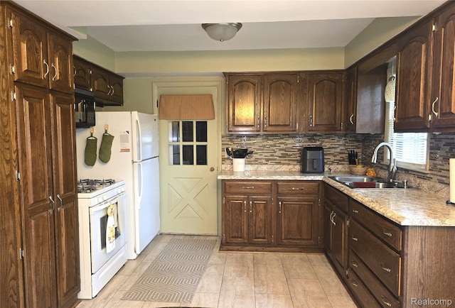 11019 Washington Ave, Mount Morris, MI 48458 - kitchen with white appliances, backsplash, and dark brown cabinets