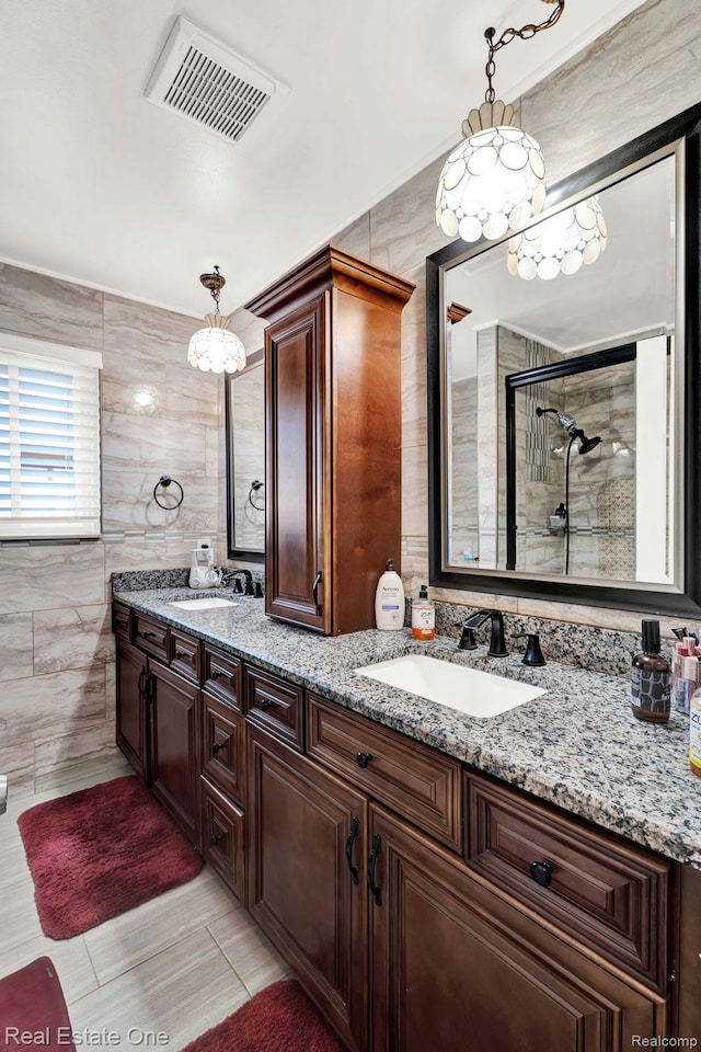2308 Kipling Dr, Sterling Heights, MI 48310 - bathroom featuring tile walls, double vanity, a chandelier, tiled shower, and tile patterned flooring