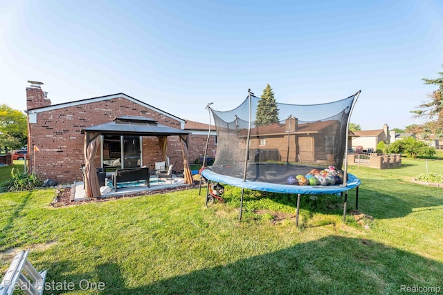 2308 Kipling Dr, Sterling Heights, MI 48310 - back of property with a trampoline, brick siding, a gazebo, a yard, and a patio
