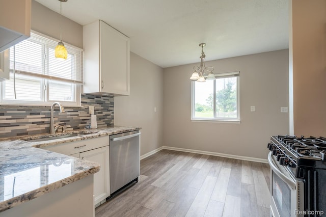 20327 Ellis St, Roseville, MI 48066 - kitchen featuring stainless steel appliances, white cabinets, light wood-style floors, and decorative backsplash