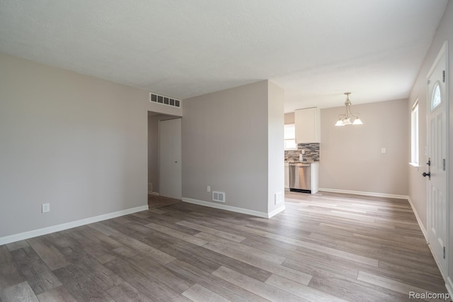 20327 Ellis St, Roseville, MI 48066 - unfurnished living room featuring a chandelier and light wood-style floors