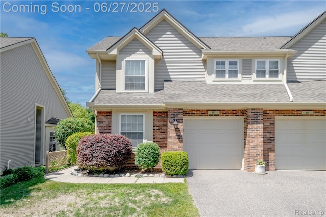 897 Whisperwood Trl, Fenton, MI 48430 - view of front facade with brick siding, a shingled roof, driveway, and a garage