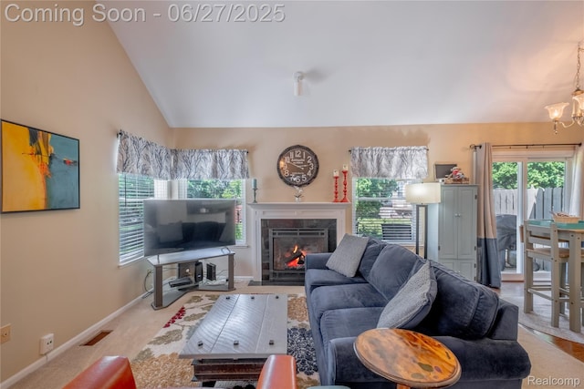 897 Whisperwood Trl, Fenton, MI 48430 - living area featuring vaulted ceiling, a chandelier, a fireplace with flush hearth, and carpet flooring