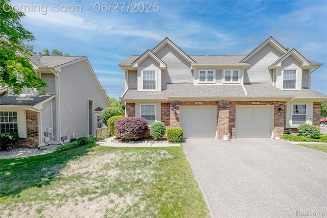 897 Whisperwood Trl, Fenton, MI 48430 - view of front of home featuring brick siding, asphalt driveway, a garage, and a shingled roof