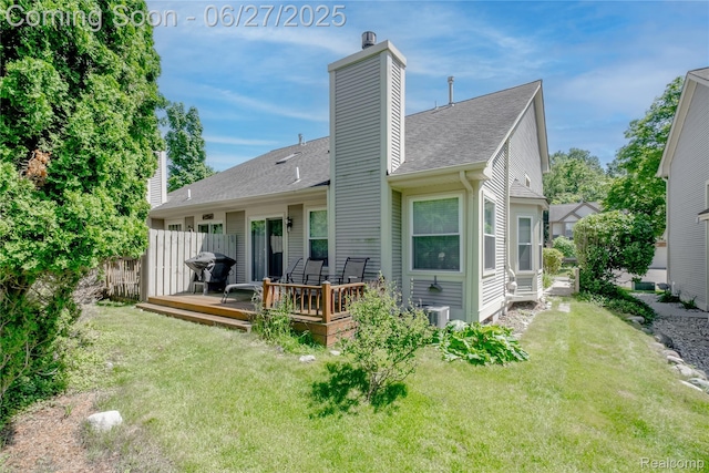 897 Whisperwood Trl, Fenton, MI 48430 - rear view of house with a chimney, a wooden deck, a lawn, and roof with shingles