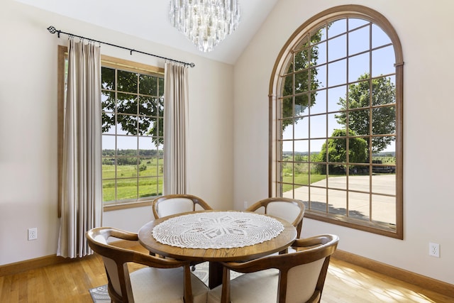 11713 Linderman Rd, Bear Lake, MI 49614 - dining space with plenty of natural light, a chandelier, vaulted ceiling, and light wood finished floors