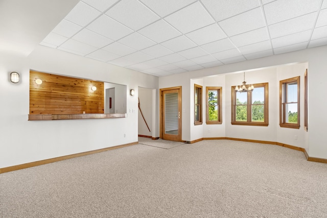 11713 Linderman Rd, Bear Lake, MI 49614 - unfurnished living room featuring carpet, a drop ceiling, and a chandelier