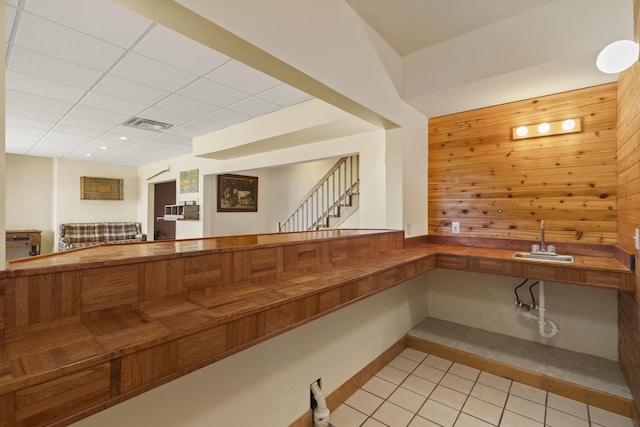 11713 Linderman Rd, Bear Lake, MI 49614 - bar with wooden walls, light tile patterned flooring, a paneled ceiling, and stairs