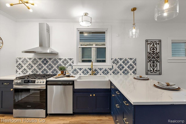 16514 Wildemere St, Detroit, MI 48221 - kitchen with stainless steel appliances, wall chimney exhaust hood, blue cabinets, a peninsula, and light wood-style flooring
