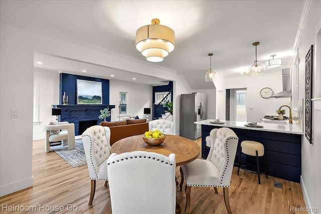 16514 Wildemere St, Detroit, MI 48221 - dining space featuring ornamental molding, light wood-style flooring, a fireplace, and recessed lighting